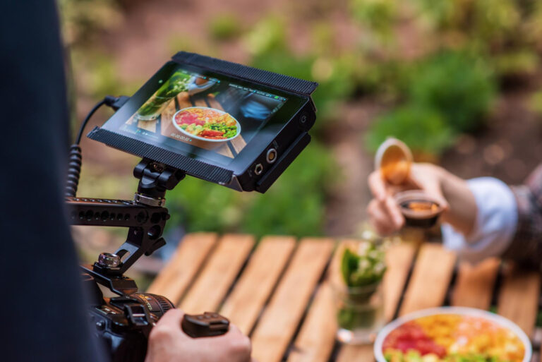 Fotógrafo disparando un poke bowl con una cámara profesional en un parque