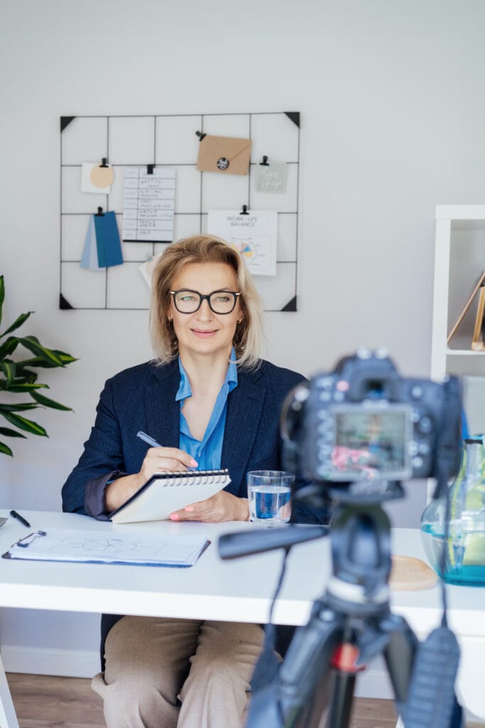 Mujer de negocios madura y segura de los 50, mediana edad con experiencia grabando vídeo vlog webinar