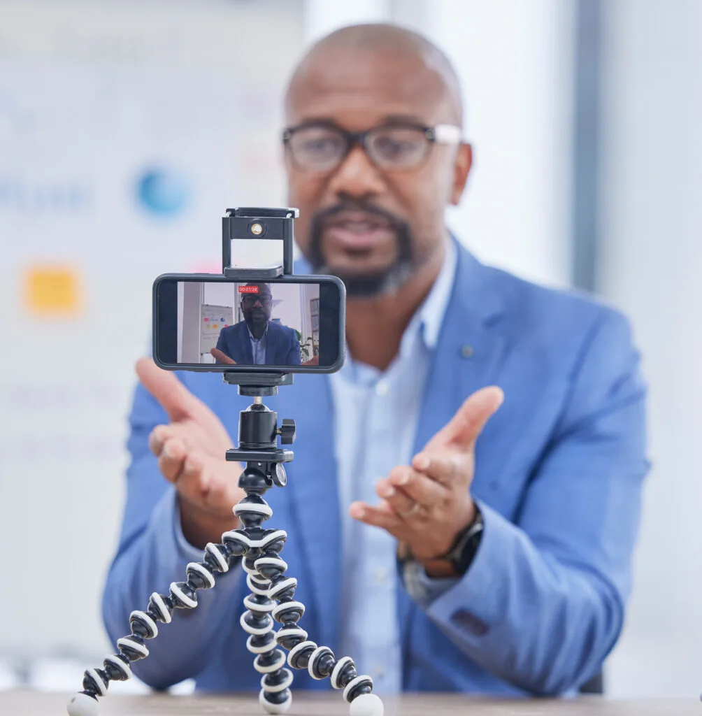 Webinar empresarial, teléfono inteligente y hombre negro hablando para entrenamiento, enseñanza y taller en línea. Comunicación