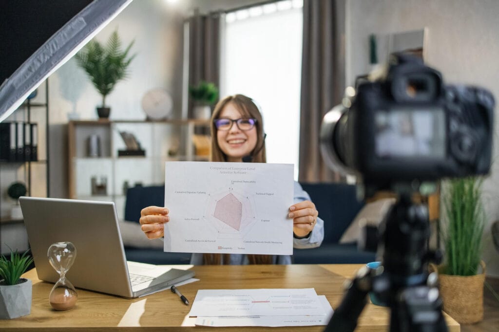 Estudiante que tiene una lección en línea usando una cámara y una computadora portátil