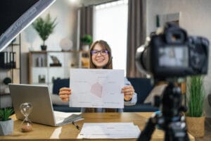 Estudiante que tiene una lección en línea usando una cámara y una computadora portátil