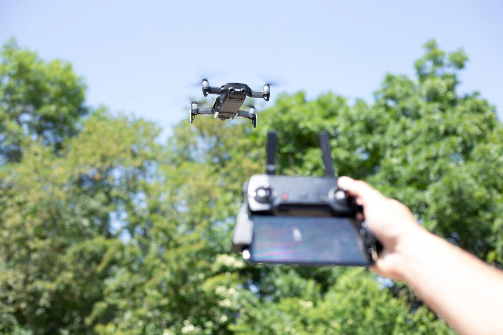 Hombre controla el avión no tripulado usando el control remoto Foto de primer plano