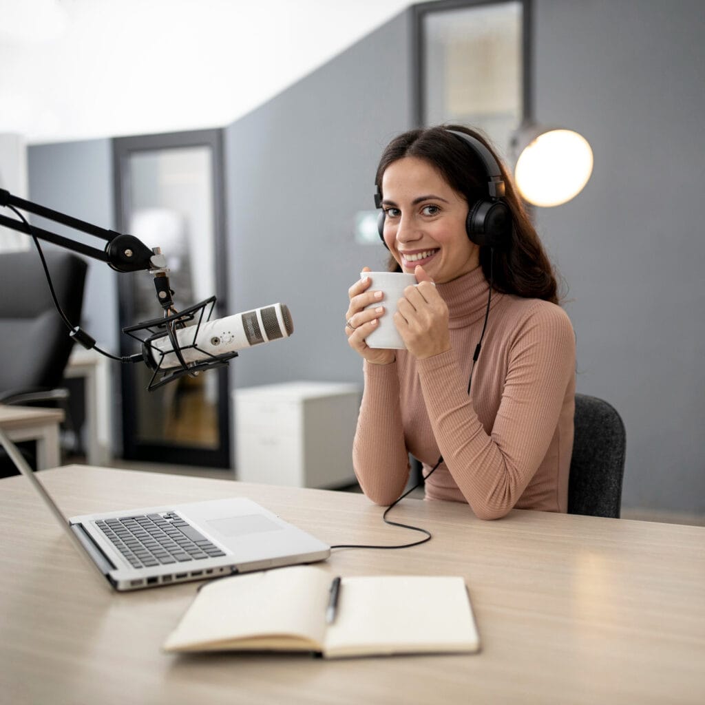 Mujer grabando pódcast con micrófono profesional y auriculares