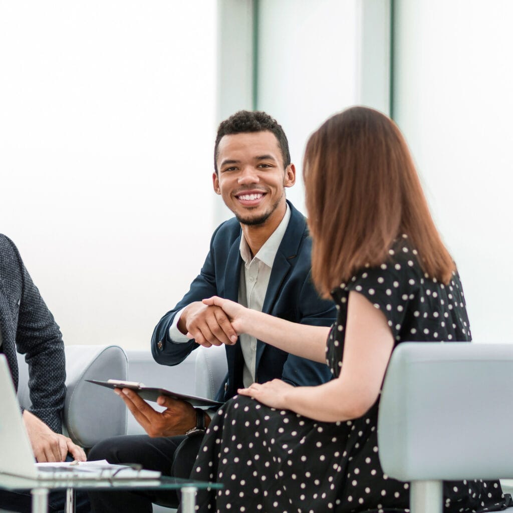 Reunión de negocios con apretón de manos entre profesionales en oficina moderna