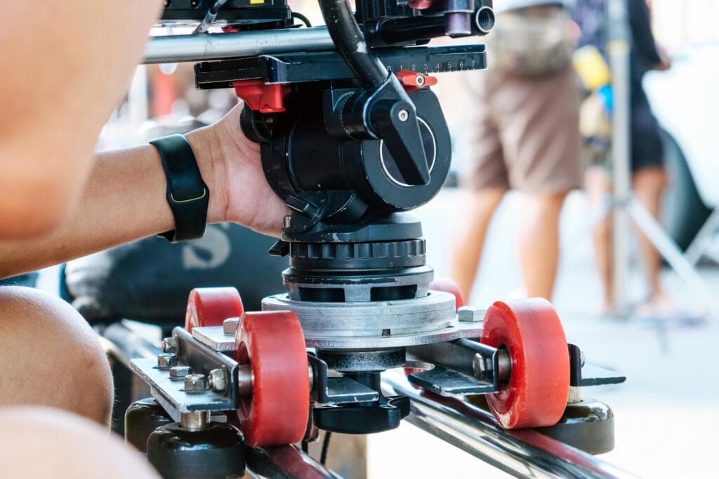 Sección media del hombre que opera la cámara con ruedas en la barandilla